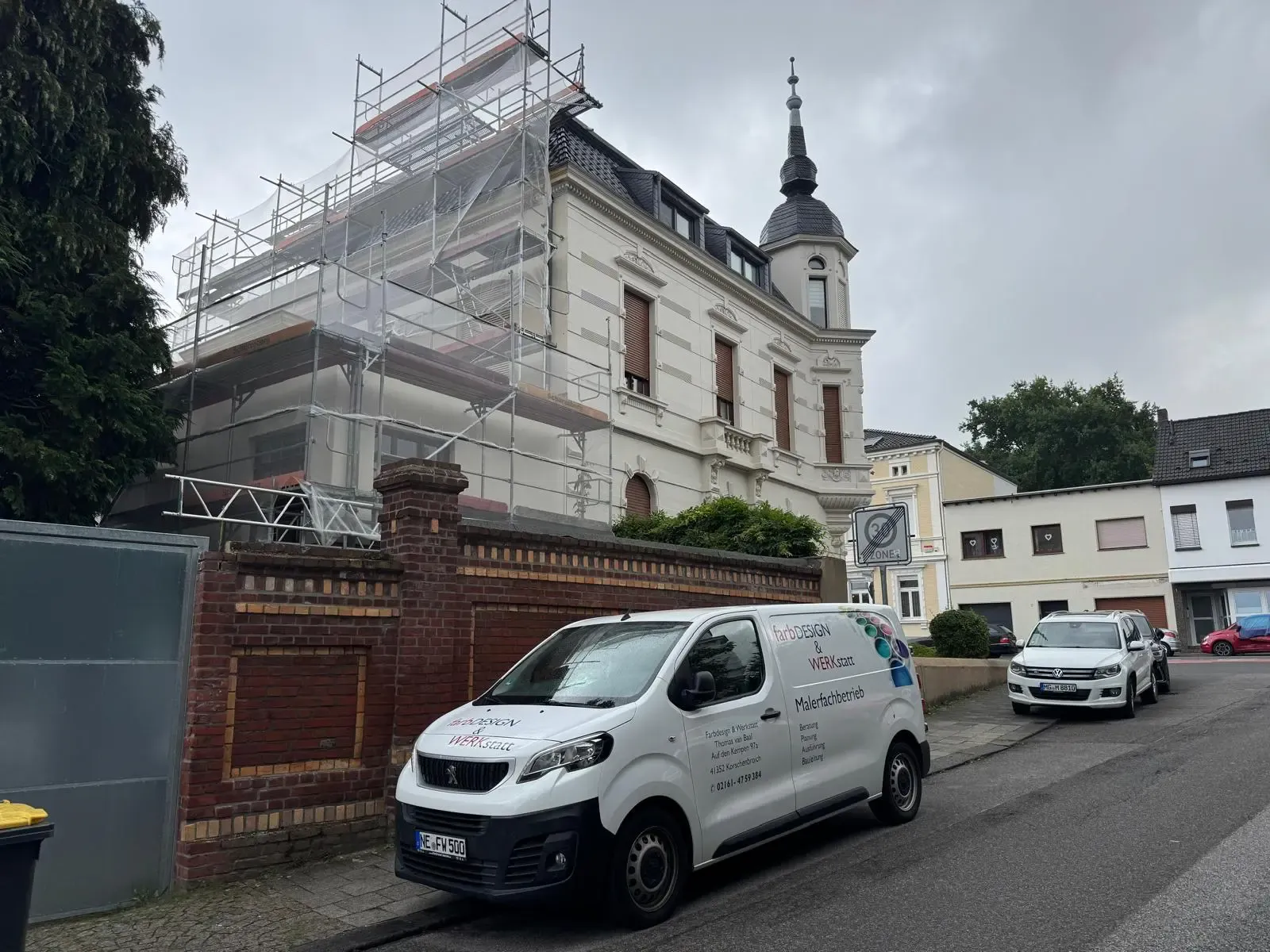 Fassadensanierung eines Altbaus in Korschenbroich – farbDESIGN & WERKstatt bei Außenarbeiten mit Gerüst und Firmenfahrzeug vor Ort.