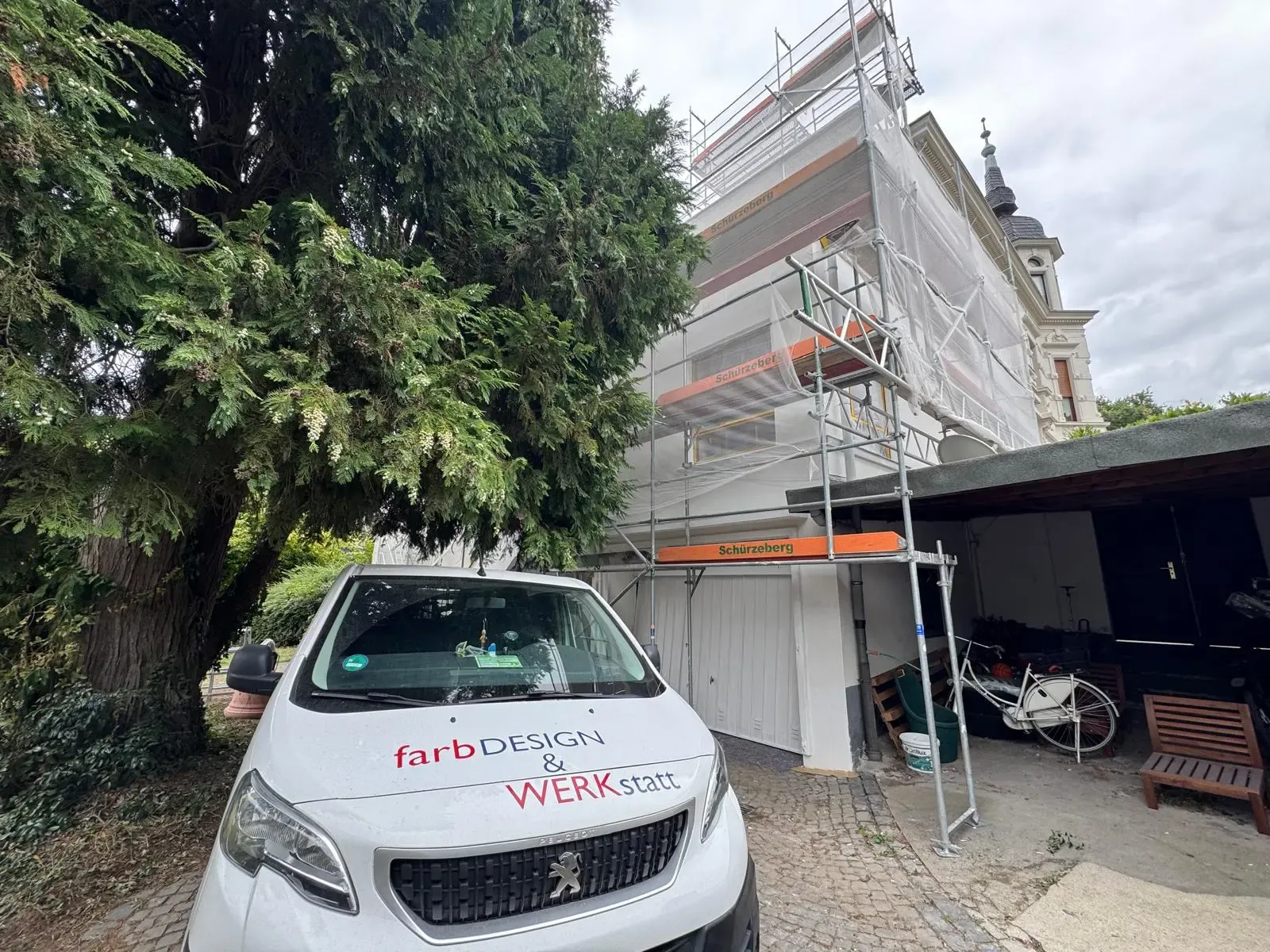 Fassadensanierung mit Gerüst und Servicefahrzeug von farbDESIGN & WERKstatt vor einem Altbau in Korschenbroich.