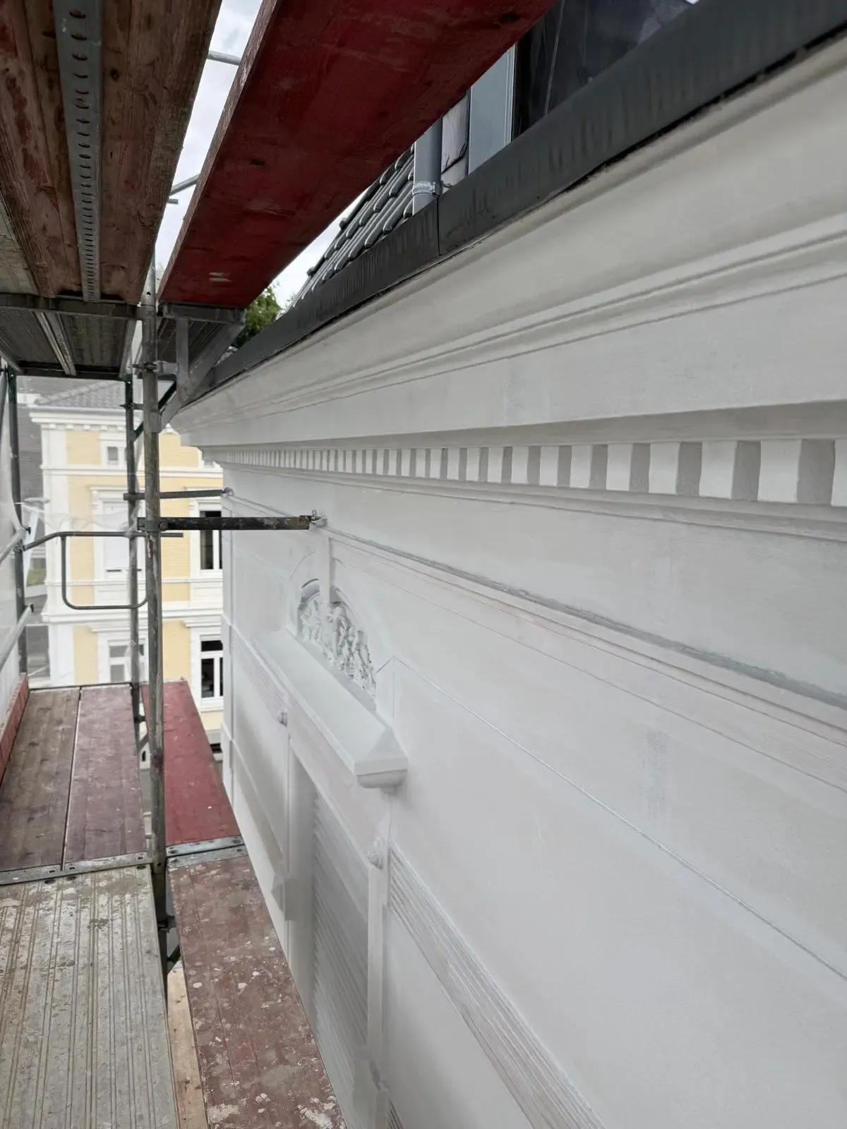 Fertiggestellte Stuckfassade nach Sanierung mit klaren Linien und Ornamenten durch farbDESIGN & WERKstatt in Korschenbroich.