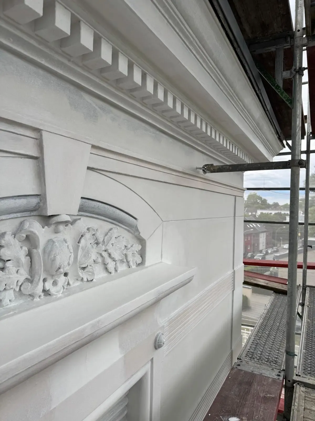 Restaurierte Stuckfassade mit Gesims und Ornamenten nach der Sanierung durch farbDESIGN & WERKstatt in Korschenbroich.