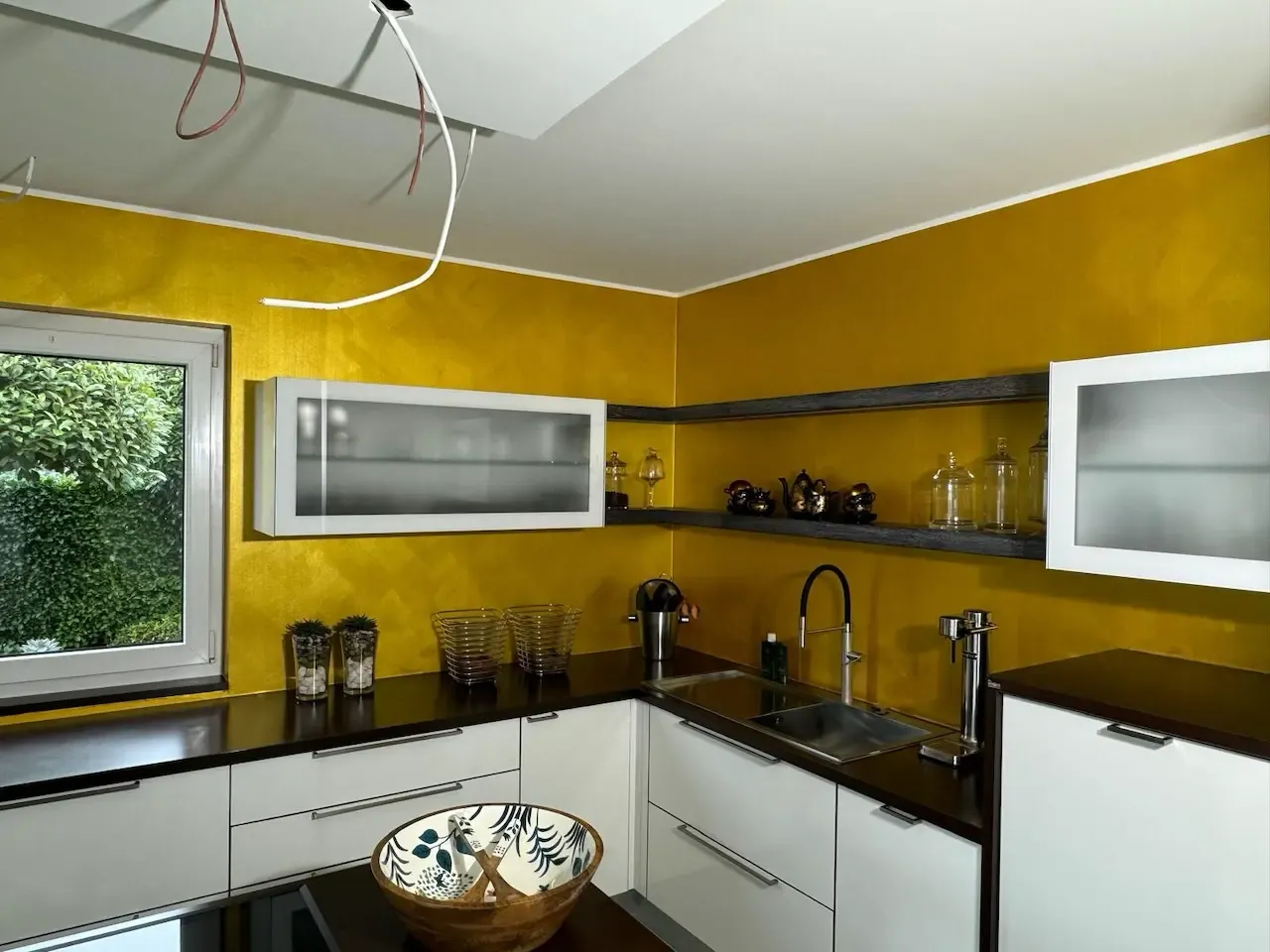 Küchenbereich mit goldener Wand und minimalistischer Einrichtung: Der Küchenbereich mit einer warmen, goldfarbenen Wand und minimalistischen Design-Elementen, die einen luxuriösen und modernen Wohnstil unterstreichen, von farbDESIGN und WERKstatt renoviert.