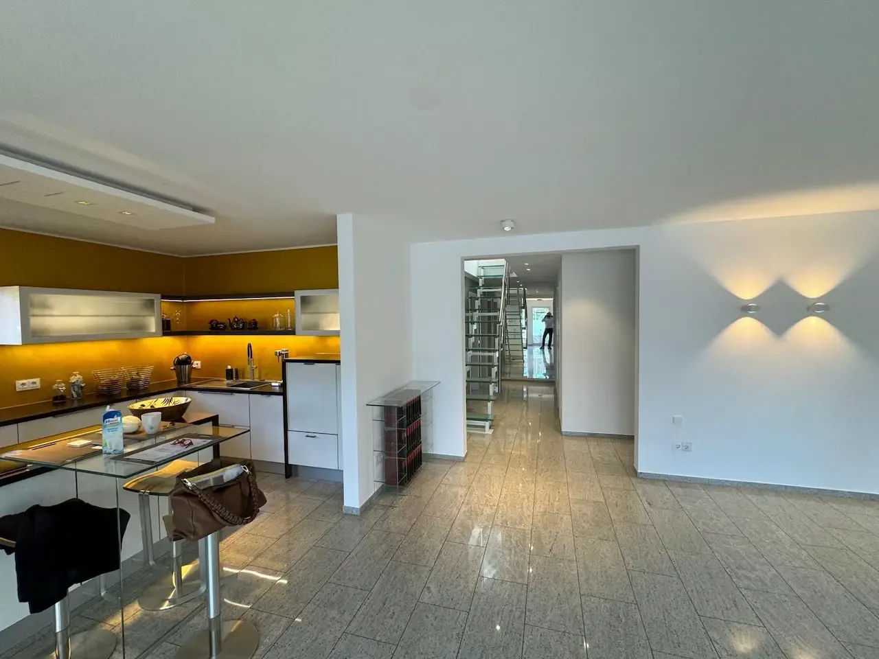 Weitläufige Wohnküche mit goldenen Wänden und minimalistischem Design: Eine elegante, modern gestaltete Küche mit goldenen Wänden und klaren Linien, die dem Raum Wärme und Exklusivität verleiht. Die Renovierung wurde von farbDESIGN und WERKstatt ausgeführt.