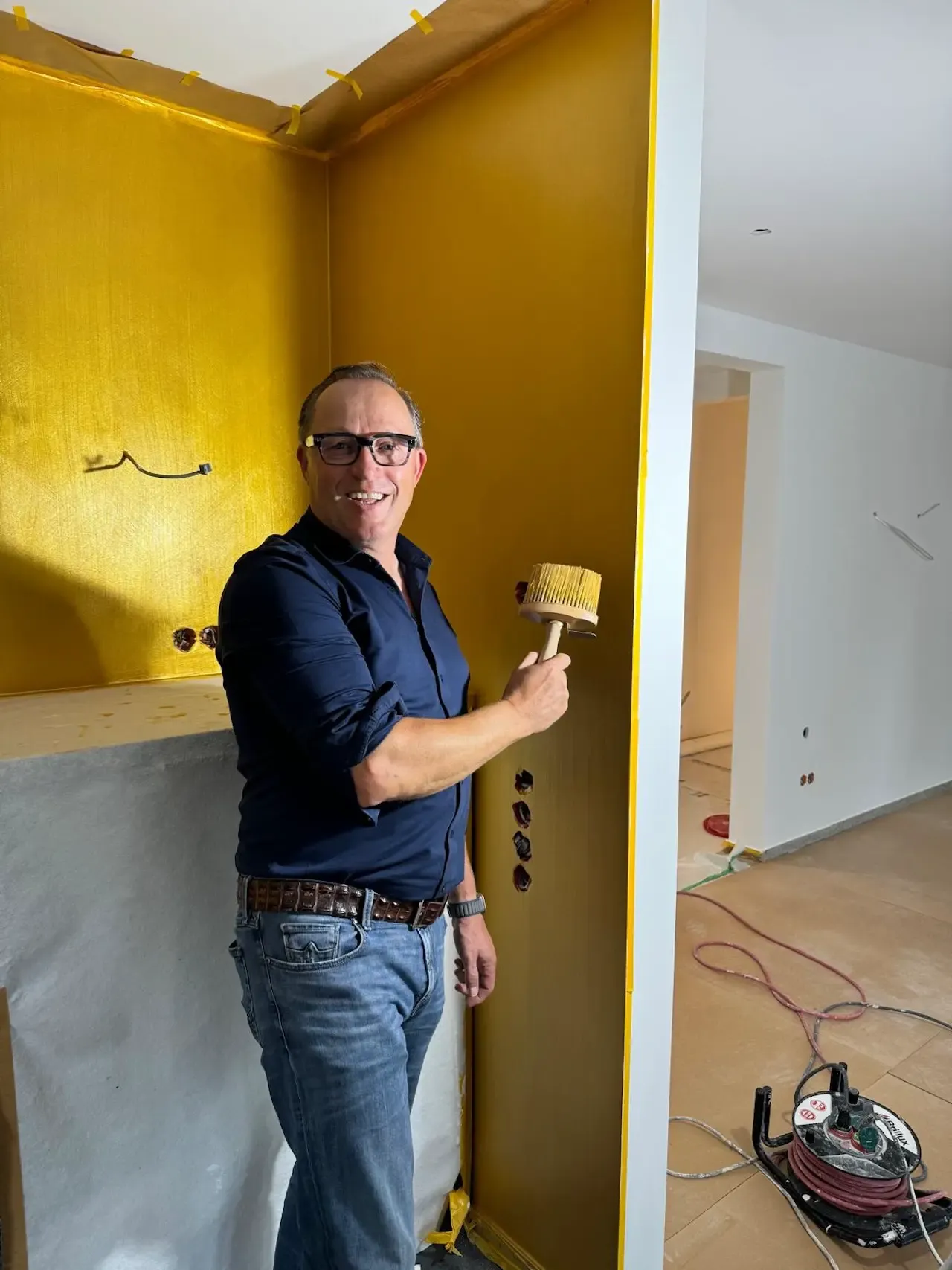 Vergoldungstechnik: Thomas van Baal von farbDESIGN und WERKstatt zeigt stolz die manuelle Vergoldungstechnik, die in der Küche verwendet wird, um eine luxuriöse und stilvolle Wandgestaltung zu schaffen.