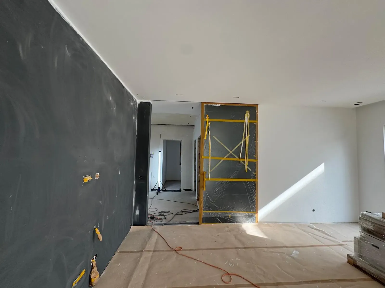 Frisch gestrichene und gespachtelte Wände in einem Neubau mit dunkler Akzentwand