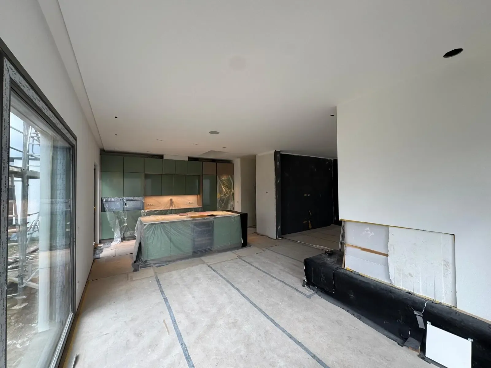 Neubau-Wohnküche mit glatten Wänden und abgedeckter Kücheninsel